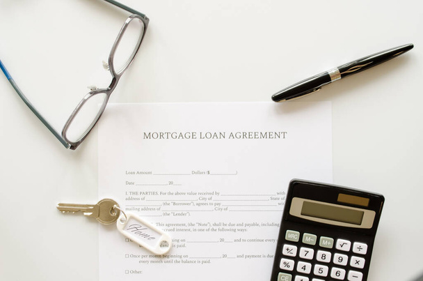 Mortgage loan agreement contract, concept with calculator, keys and pen on mortgage form or contract. Top view. - Photo, Image