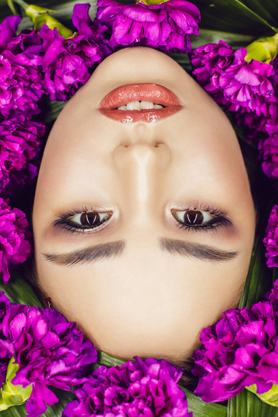 Woman with make-up and flowers around her face. Woman and flowers. Spring. - 写真・画像