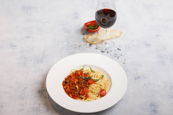 болоньская паста с помидорами черри на белой тарелке
 - Фото, изображение