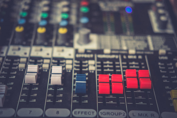 Деталь с регулирующими кнопками на профессиональном аудио миксере и музыкальном оборудовании для управления звуковым миксером
 - Фото, изображение