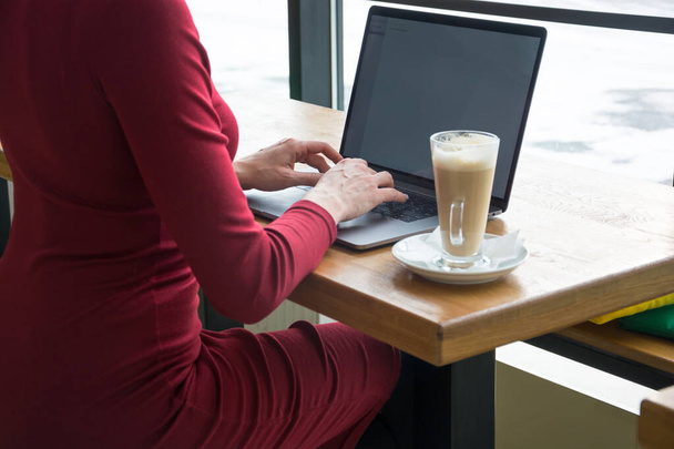 Work at home. Young woman with laptop and a coffee is working at home - Фото, зображення