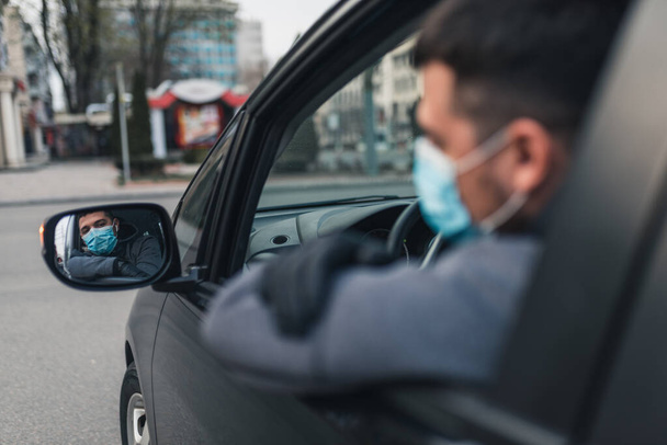 Man in the medical mask and rubber gloves for protect himself from bacteria and virus while driving a car. masked man in a car. coronavirus, disease, infection, quarantine, covid-19 - Photo, Image