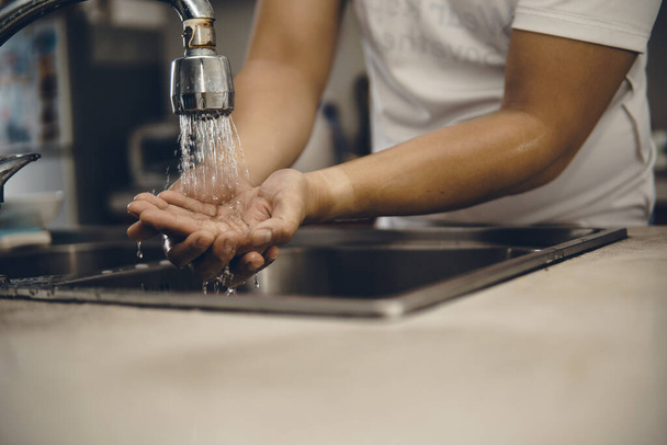 Always start with clean hands to prevent spreading of the coronavirus (Covid-19). Cropped shot of an asian man washing his hands at home - Foto, imagen