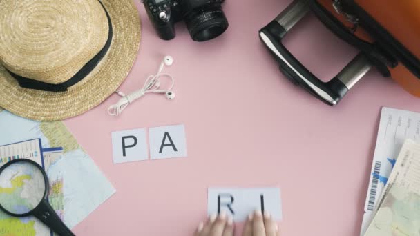 Góra widok ręce leżące na różowym biurku słowo PARIS - Materiał filmowy, wideo