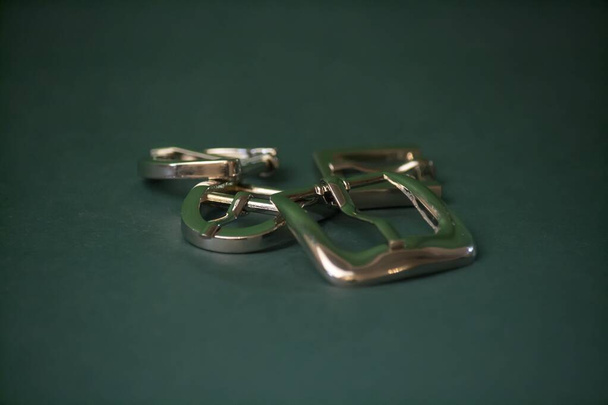 White nickel-plated buckles on a green background - Photo, Image