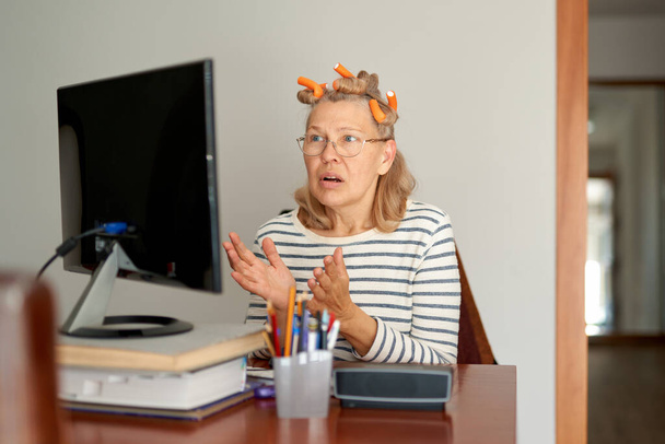 Rentner mittleren Alters mit Brille tippt E-Mail am Laptop im Home Office - Foto, Bild