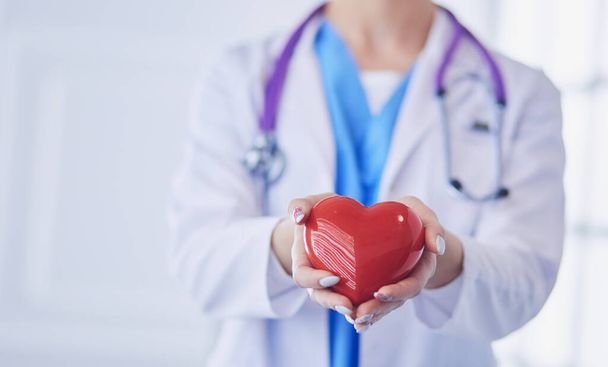 Doctor with stethoscope holding heart, isolated on white background - Фото, зображення