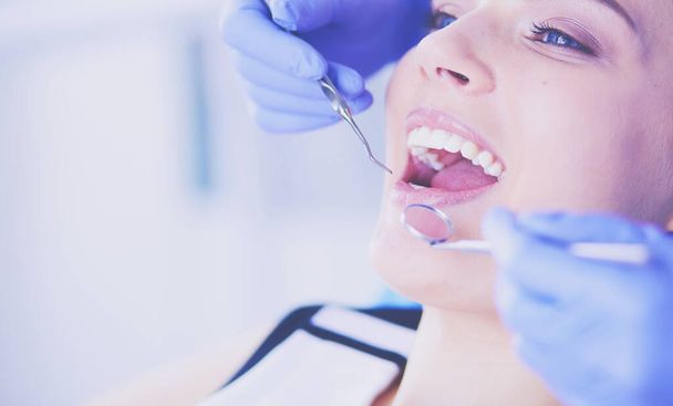 Young Female patient with open mouth examining dental inspection at dentist office. - Фото, зображення