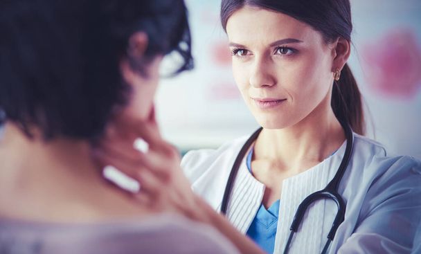 Un médecin féminin sérieux examinant les ganglions lymphatiques d'un patient - Photo, image