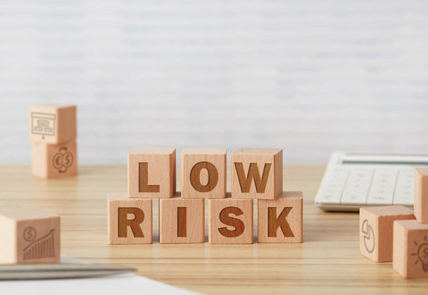 Low risk wooden cubes on office table - Foto, Bild