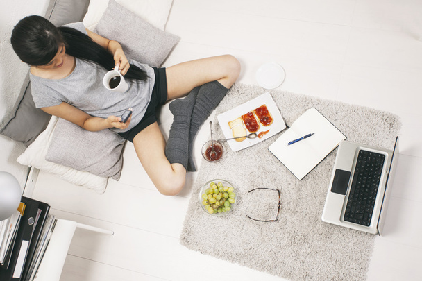 Casual asian woman having breakfast and working in home. - Foto, afbeelding