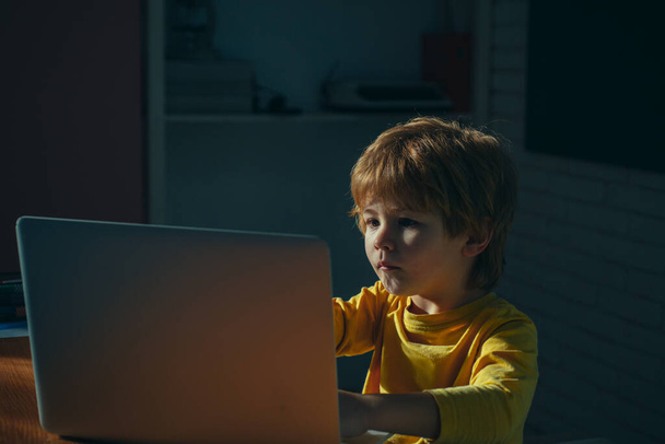 Retrato de Genio. Un joven trabajando en la computadora sentado en la mesa. Estudiando. Aprendizaje en línea remotamente. La escuela distante. Educación a distancia. Cursos y conocimientos en línea
. - Foto, Imagen
