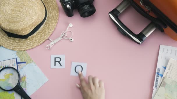 Góra widok ręce leżące na różowym biurku słowo ROME - Materiał filmowy, wideo