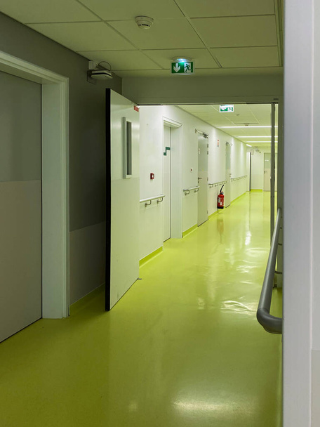 Amplia vista de perspectiva del pasillo hospital vacío con puerta
 - Foto, imagen