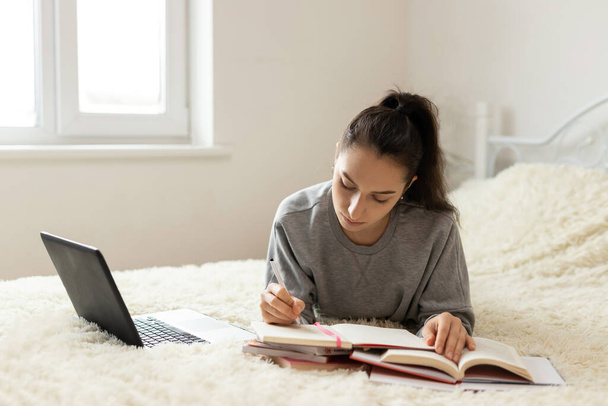 Mujer joven aprendizaje a distancia para los estudiantes. Cuarentena. freelancer, trabajo a distancia, trabajo en casa, educación en línea
 - Foto, imagen
