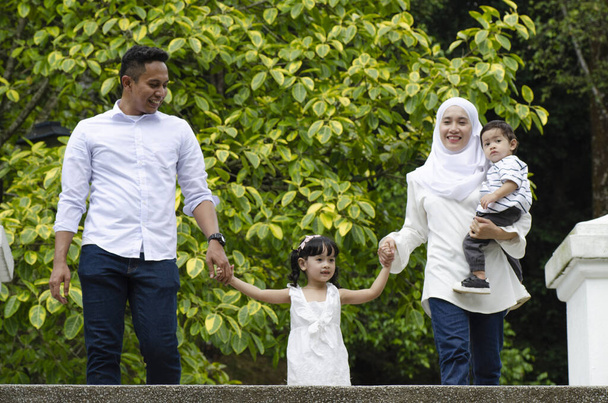 Concept familial heureux, les jeunes parents passent du temps avec leurs enfants au parc pendant le week-end
 - Photo, image