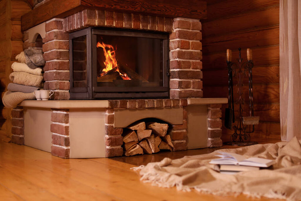 Fireplace with burning wood in room. Winter vacation - Photo, Image
