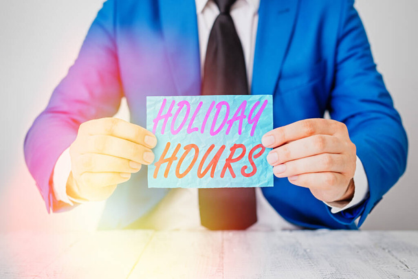 El yazısı, Holiday Hours. Bu kavram, esnek çalışma saatleri altında çalışanlar için fazla mesai anlamına geliyor. Önünde kopyalama alanı olan boş bir kağıt tutuyor. Boşluğu kopyala. - Fotoğraf, Görsel