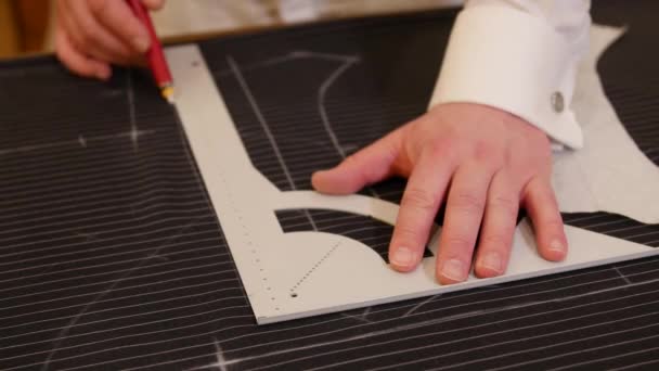 Kavkazská švadlena kreslí křídovou tužkou na plátně. mužský módní návrhář kreslí náčrty. Detailní záběr procesu: Módní tvorba a design pro výrobce obleků - Záběry, video