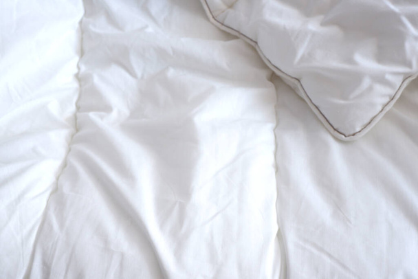 Soft white blanket. The sun's rays fall on the bed linen. Cosiness - Valokuva, kuva