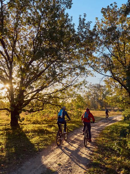 Cyklisté na kole projíždějí západ slunce. - Fotografie, Obrázek