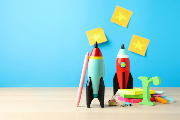 Bright toy rockets and school supplies on wooden table. Space for text - Foto, Imagen