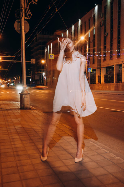 nuori tyttö kesämekossa kävelee ympäri kaupunkia yöllä
 - Valokuva, kuva