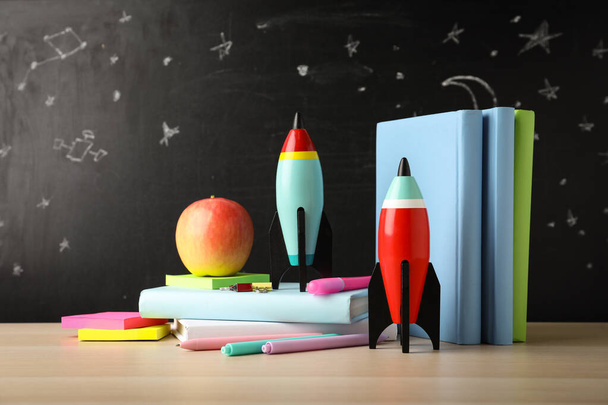 Bright toy rockets and school supplies on wooden table - Fotó, kép