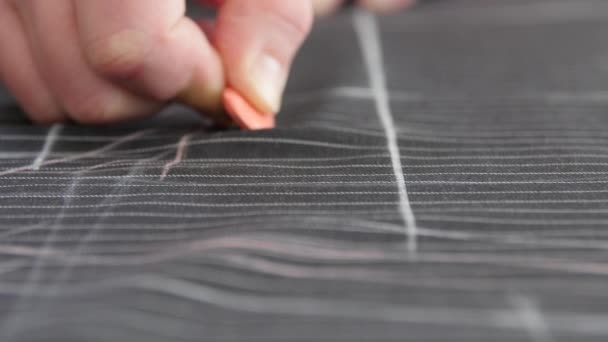 Man Tailor Výroba šicích vzorů na stole. Close Up Of Hands Tracing Lines on wool Fabric Clothes In fashion designer Atelier. Vzory pro práci na míru a kreslení - Záběry, video