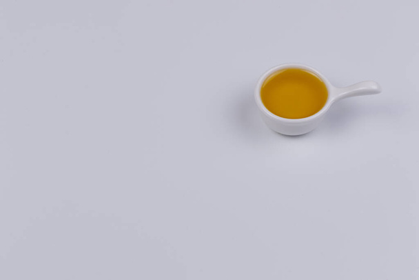 El aceite de oliva en un recipiente sobre un fondo blanco. Aislar
 - Foto, Imagen