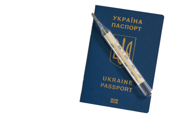 ιατρικό θερμόμετρο βρίσκεται σε ένα ουκρανικό ξένο διαβατήριο - Φωτογραφία, εικόνα