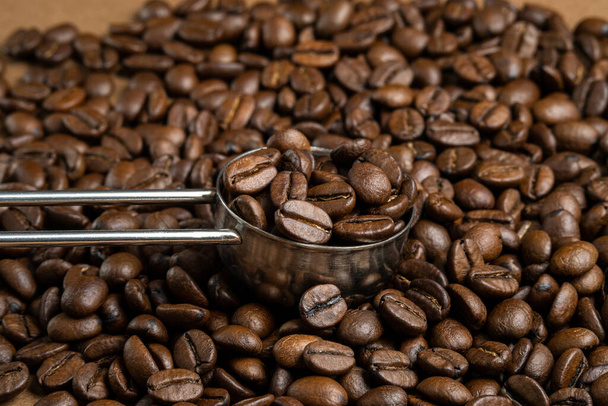 Kaffeebohnen und Messlöffel mit Kaffee gefüllt - Foto, Bild