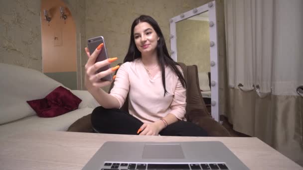 девушка держит смартфон глядя на камеру живой разговор на видео-звонок
 - Кадры, видео