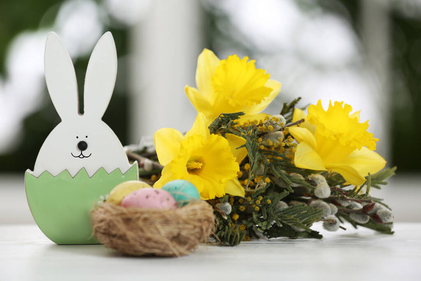 Festive composition with Easter eggs on table against blurred window - Photo, image