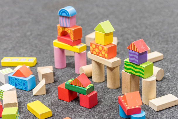 torres feitas de blocos de madeira coloridos dispostos em um piso cinza
 - Foto, Imagem