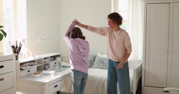 szczęśliwy Mama i nastolatek córka taniec skoków w domu - Materiał filmowy, wideo