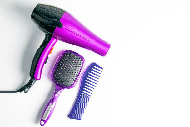 Professional hairdresser's set on white background, top view. Hairdryer, hair brushes, combs. - Photo, Image