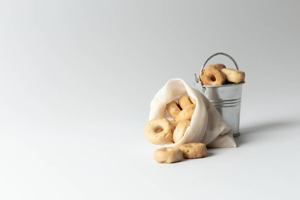 Small cooked snacks in an iron retro bucket and eco bag. Proper nutrition. On white background. - 写真・画像