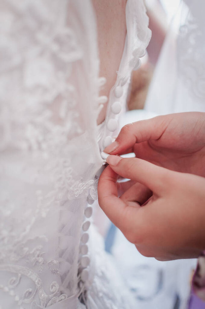 demoiselles d'honneur aider la mariée à porter une robe de mariée
 - Photo, image