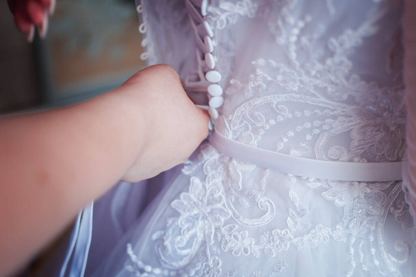 Las damas de honor ayudan a la novia a usar vestido de novia
 - Foto, Imagen