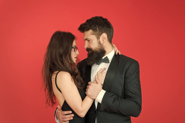We are together. Couple in love red background. Loving couple hug in formal wear. Married couple celebrate wedding anniversary. Couple of sensual woman and bearded man. Valentines day. Romance. Love - Фото, изображение