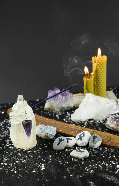 Set of many different psychic things on black background. Amethyst crystal pendulum loading on selenite stone column. - Photo, Image