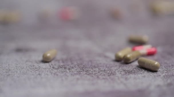 lääketieteelliset kapselit putoavat lattialle, lähikuva - Materiaali, video