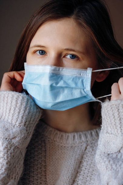Ritratto di giovane donna che indossa una maschera medica, per proteggere da virus, germi e batteri durante le epidemie di coronavirus e l'epidemia di influenza. Guardando la telecamera, da vicino
.  - Foto, immagini