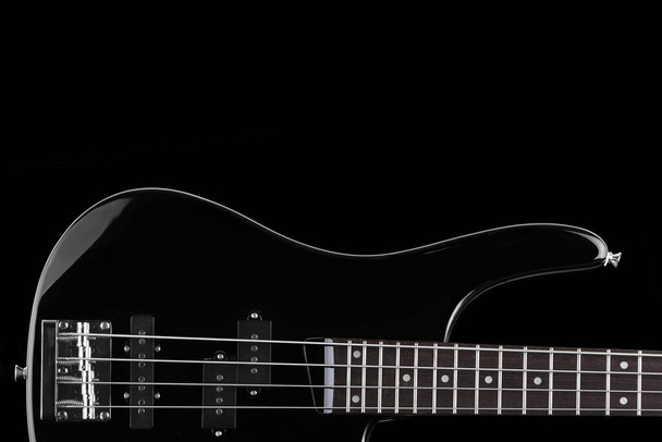 Black electric bass guitar on black background with copy space - Photo, Image