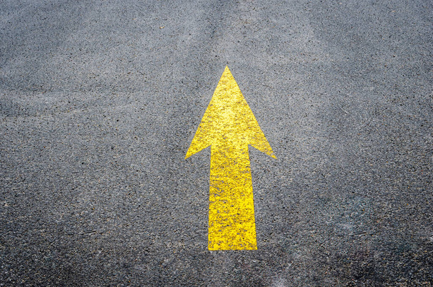 Yellow arrow on black pavement pointing ahead - Photo, Image