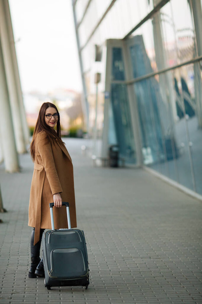 Travel, business trip. People and technology concept - happy young woman with travel bag on city street. - Foto, Imagem