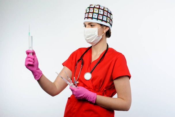 жінка-лікар тримає шприци в руках, в медичній масці, у відображенні
 - Фото, зображення