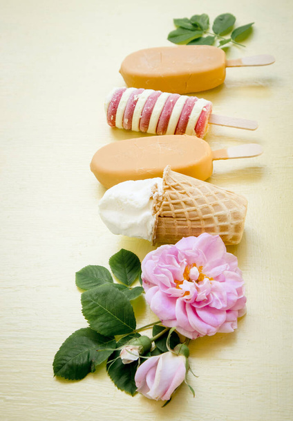 Ποικιλία πολλών διαφορετικών τύπων και χρωμάτων παγωτών σε κίτρινο φόντο. - Φωτογραφία, εικόνα