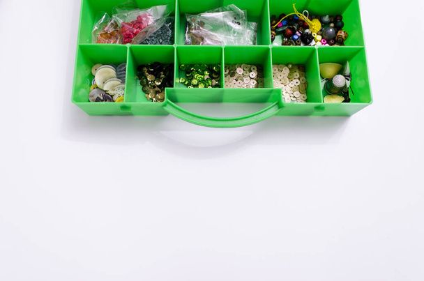 緑のプラスチックの木箱のクローズアップで縫製のための材料。トップ表示 - 写真・画像